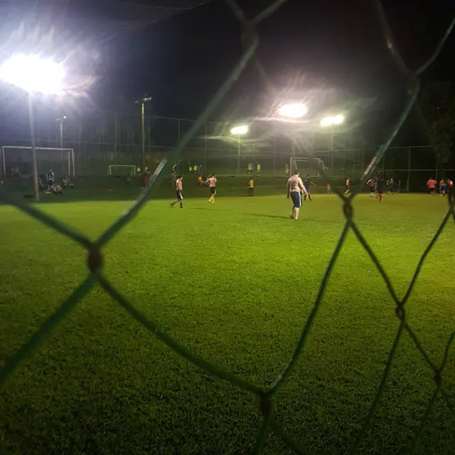 Jogo de futebol 7 à noite com refletores ligados