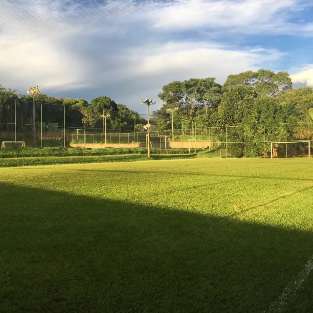 Campo de futebol society iluminado pelo sol da tarde