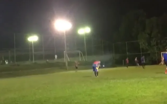 Campo de futebol society iluminado por refletores à noite, o horário mais procurado